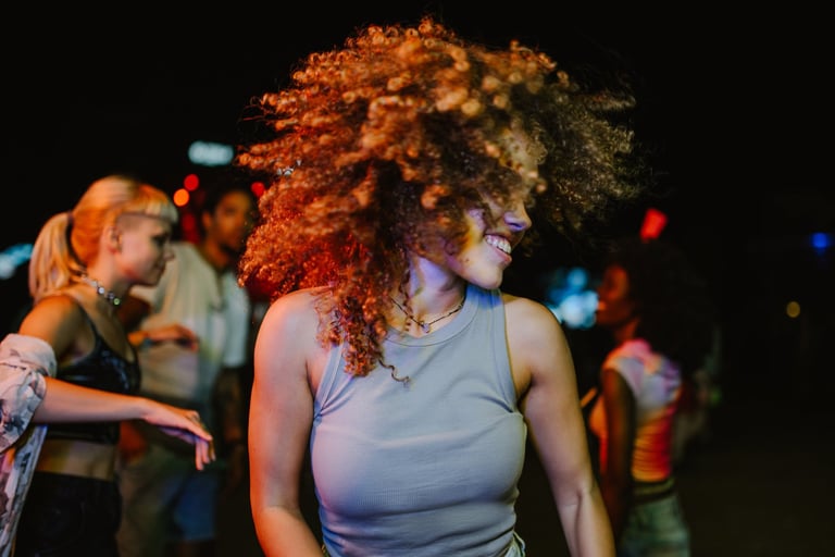 Carefree young woman enjoying music and dancing