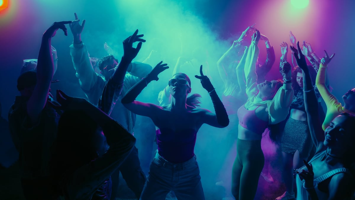 Vibrant party scene with people dancing under colorful lights